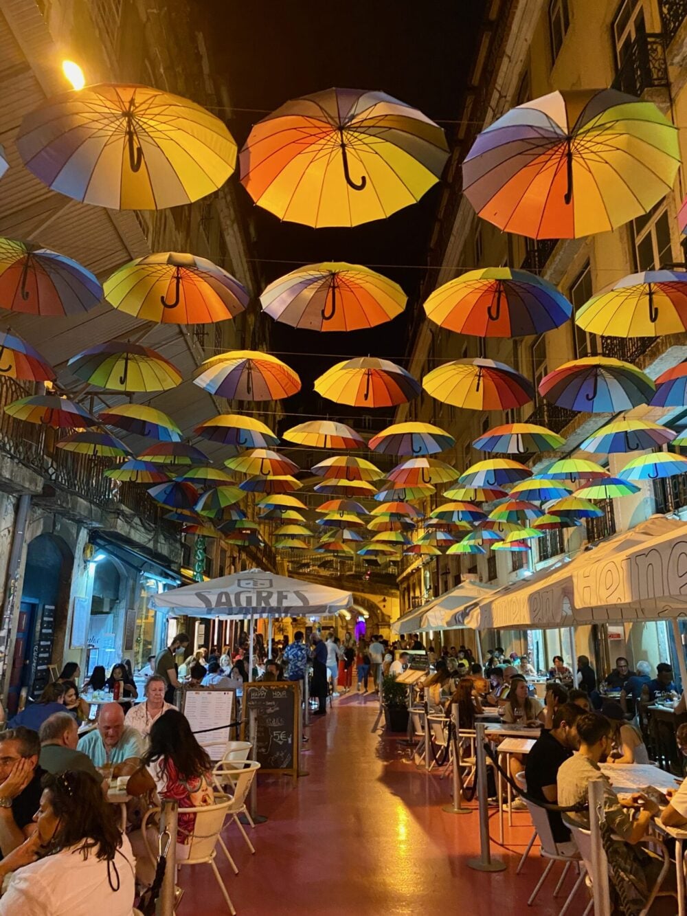 Colourful umbrellas above Pink Street (Rua Nova do Carvalho) in Cais do Sodré, Lisbon